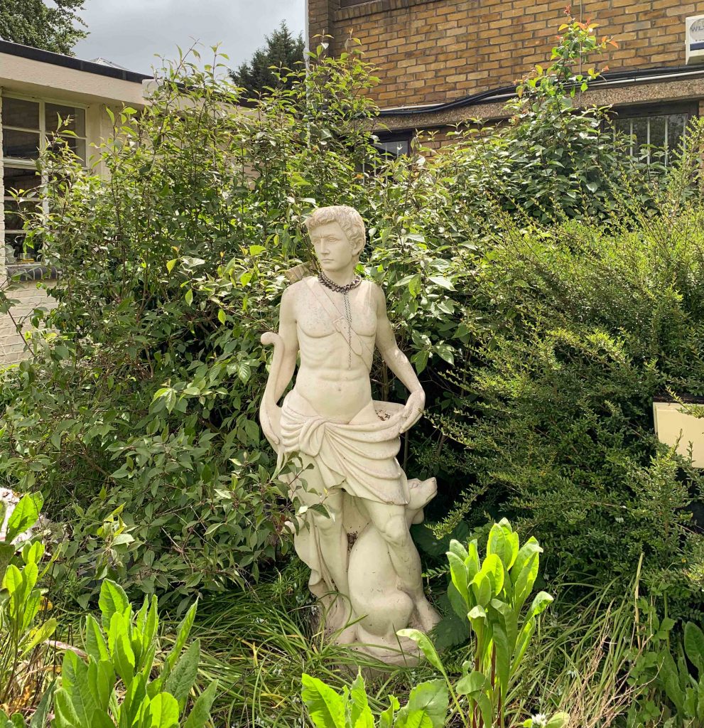 statue in garden wearing necklace