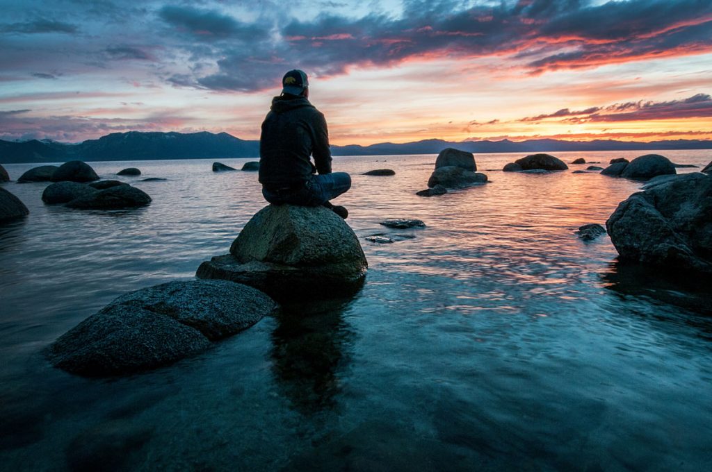 Man sat on rock in hat